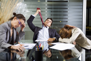 Photo of frustrated, angry businesspeople around a table