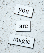 Photo of words saying "you are magic" on a speckled black-and-white background