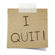 Photo of a square piece of brown paper taped up with the words I QUIT!