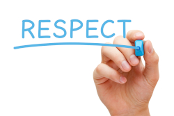Photo of a hand writing RESPECT in blue marker