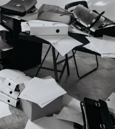 Black-and-white photo of files and papers and furniture all over the place