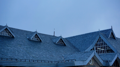 Photo of a gray roof with gable peaks against a blue sky