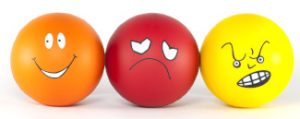 Graphic of three cartoon faces; one is orange and smiling, one is red and sad, and one is yellow and frowning.