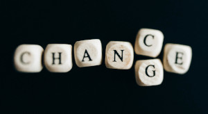 Photo of letters on cubes, on a black background. Can be read as CHANCE or CHANGE.