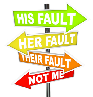 A set of four arrow signs in different colors, reading (from top to bottom), "HIS FAULT," "HER FAULT," "THEIR FAULT," "NOT ME"