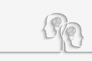 Line drawing, in grayscale, of two heads facing away from each other but intersecting, each with a lightbulb inside.